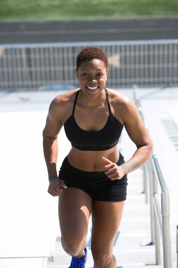 woman wearing black sports bra and jogger shorts smiling